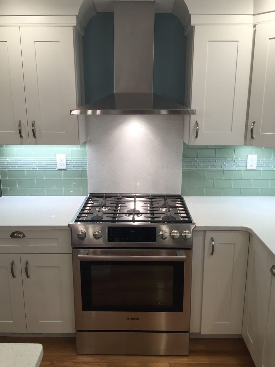 Gas range under a stainless chimney hood
