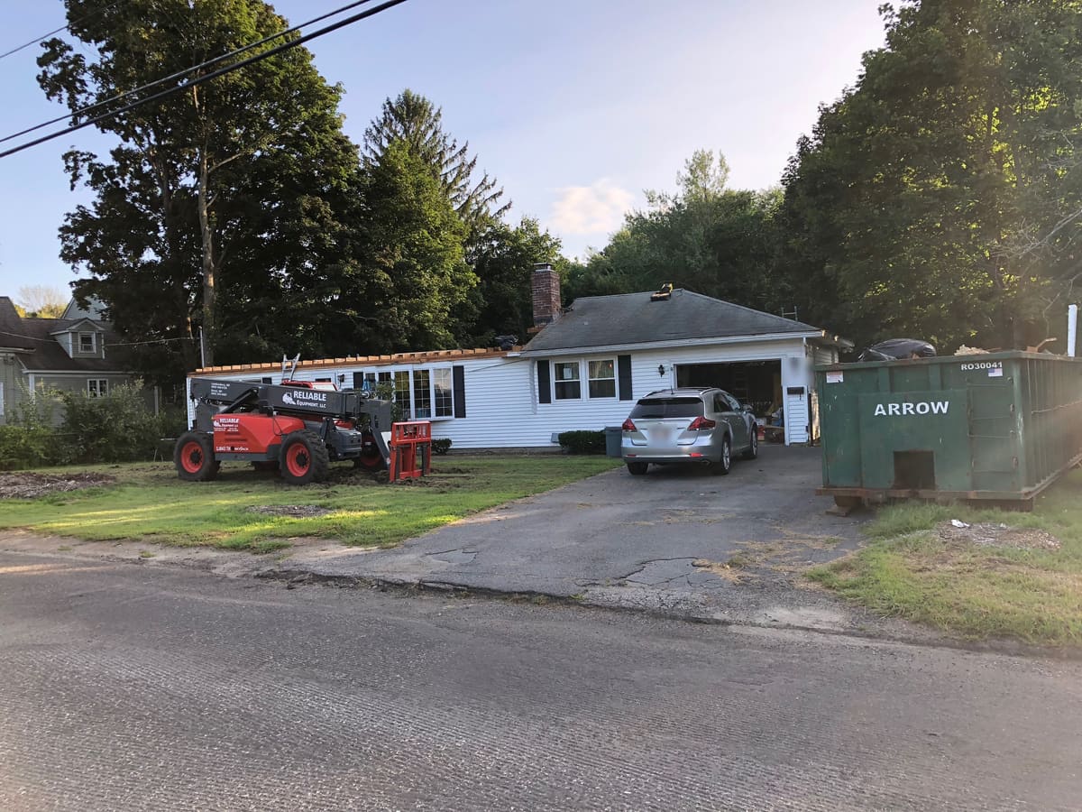 Tear-off under way, telehandler and dumpster staged